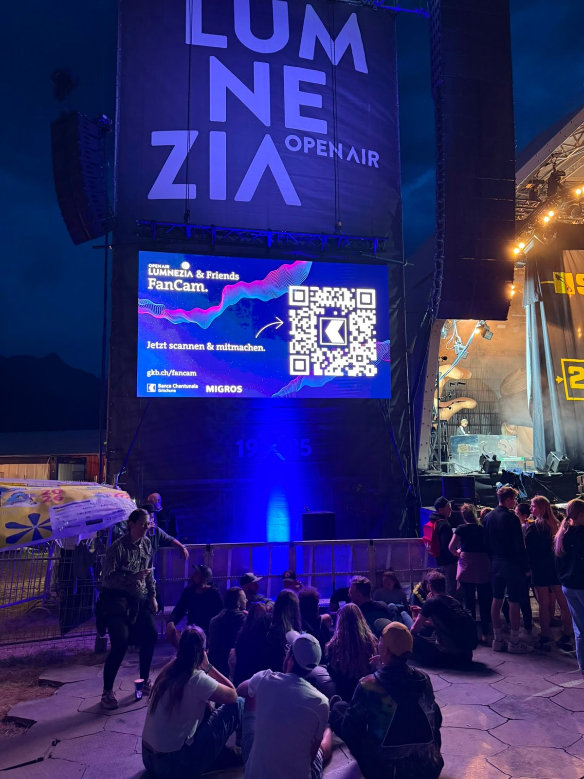 Lumnezia & Friends FanCam auf dem Bildschirm neben der Festivalbühne